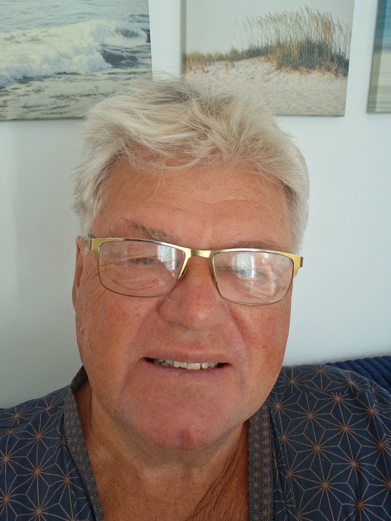 Porträtt av Kaj Utter, konstnär i Sundsvall, framför tavlor med hav och strand